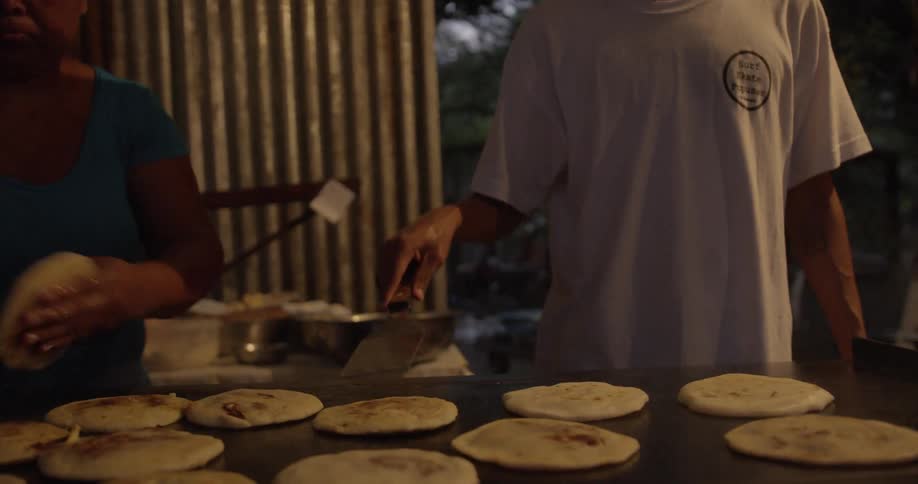 Two people are cooking food indoors