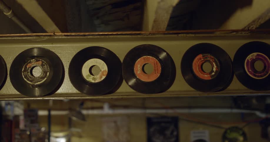 Vinyl records laid on a metal beam in a shop