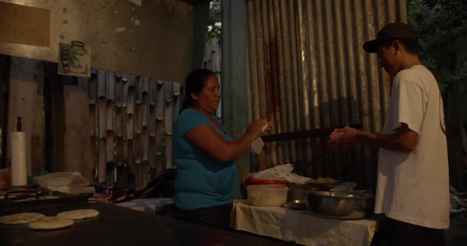 Man and woman roll dough into balls for flatbread