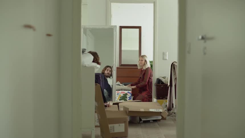 Man and woman pack their clothes in boxes during daylight