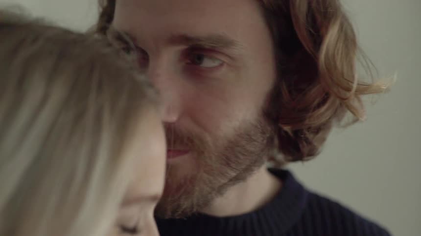 Man looking lovingly at his female partner and kissing her forehead