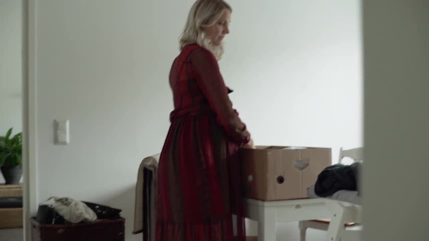 A woman and man are putting clothing into boxes