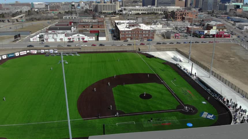 A baseball match viewed from the air is an area of greenery in an otherwise built up urban area
