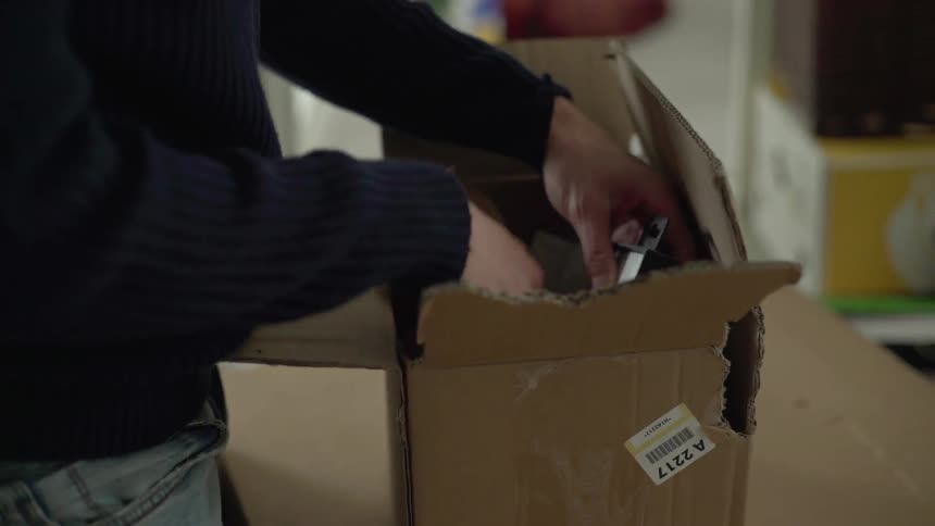 A person pulls an item out of a box