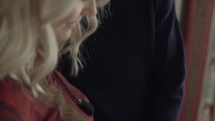 A man and a woman smile at each other while rubbing her pregnant stomach