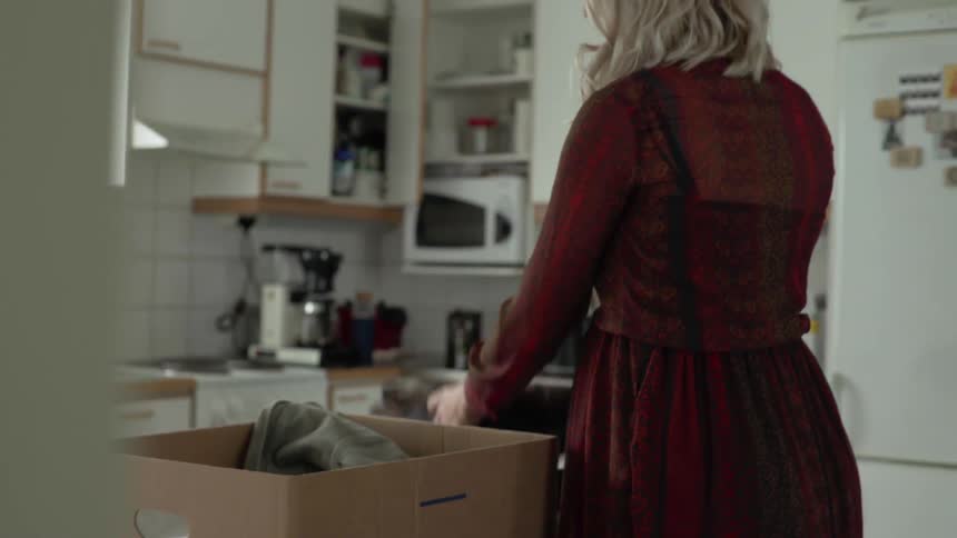 A woman taking clothes out of a box