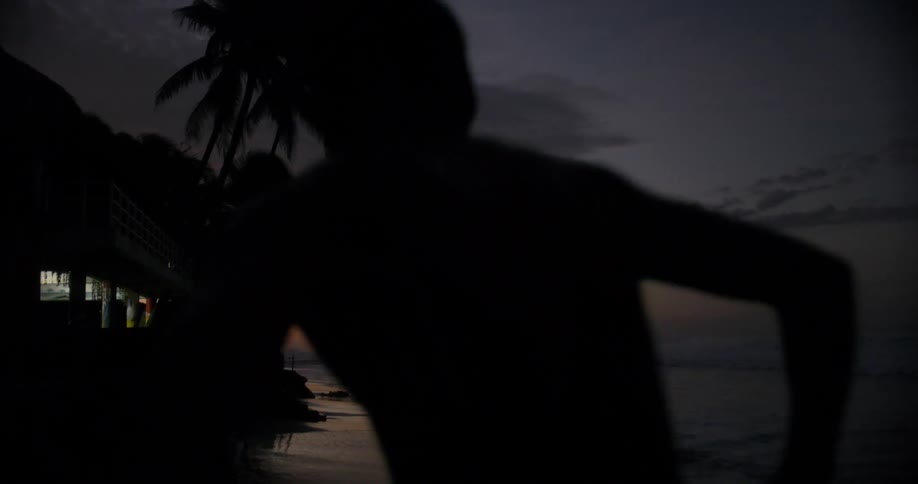 Man runs across beach as wave ebbs