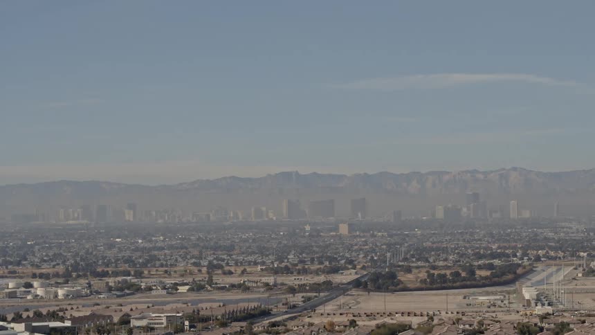A large city sits in front of a mountain range