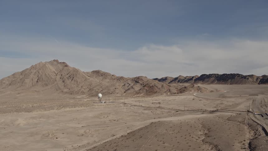 A road leads to mountains and a dome on a tower