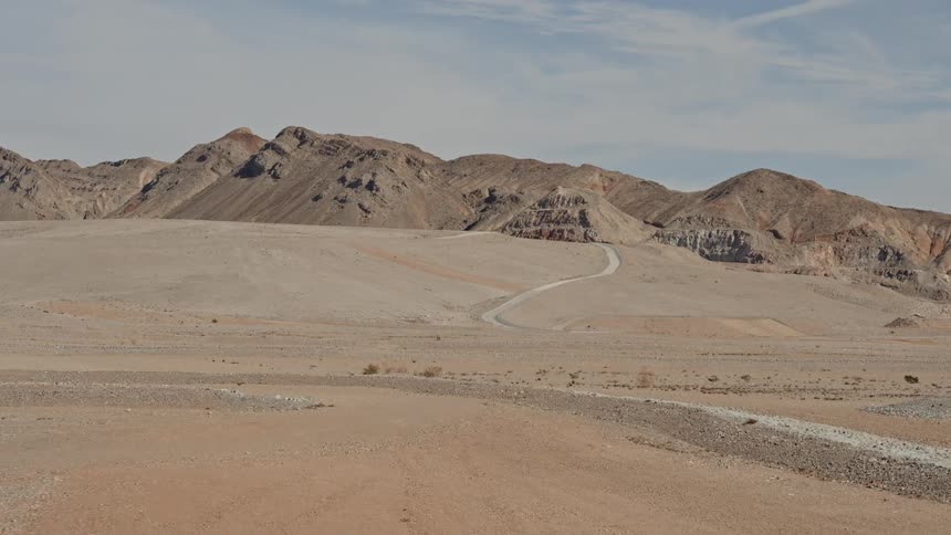 A trail runs into the mountains of the desert