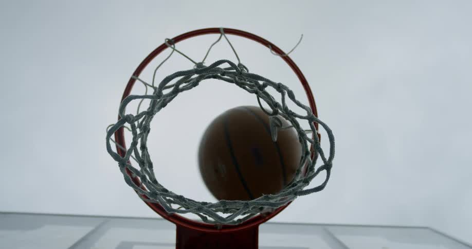 The basketball falls through the hoop