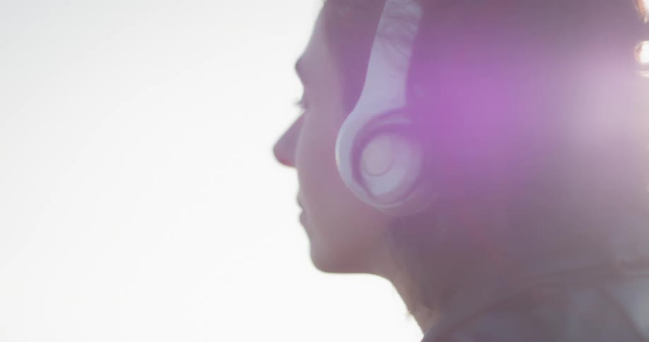 A woman puts on her headphone on a windy day