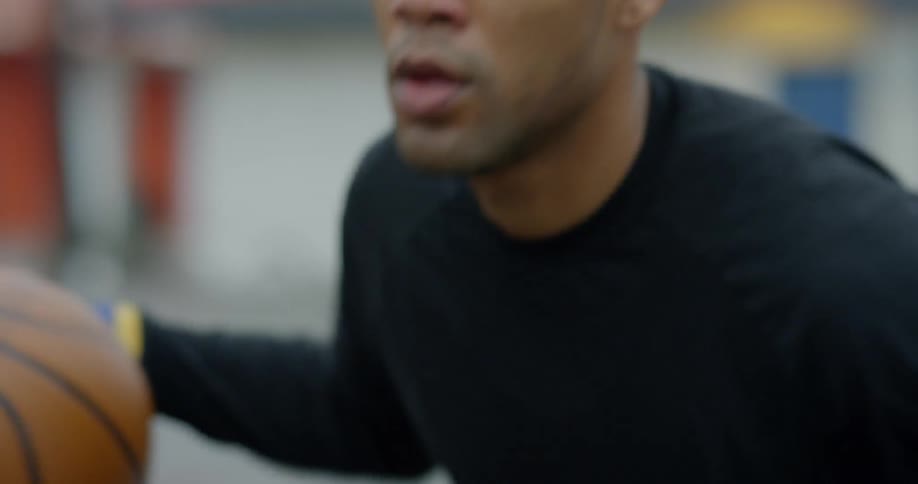 Man bounces a basketball outdoors