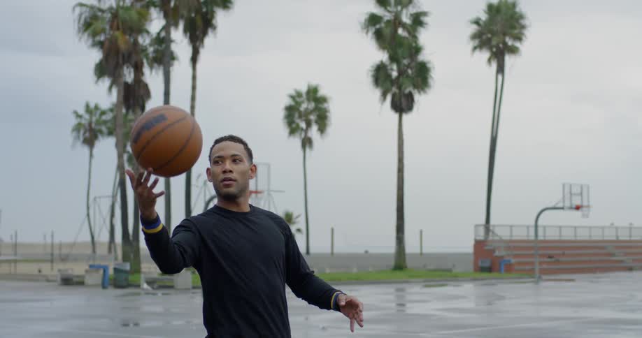 A man twirls the basketball on his finger