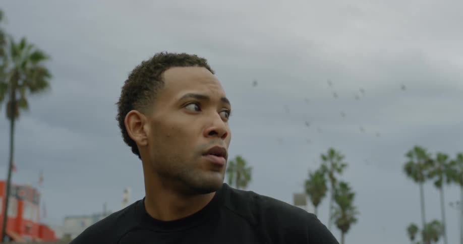 A black man looks off in to the distance