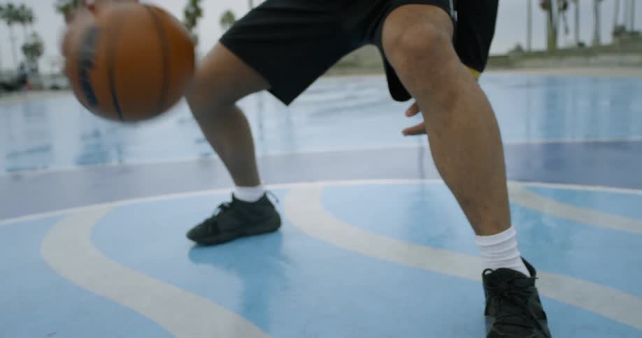 A man dribbles a ball on a colorful court