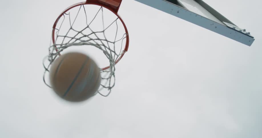 A basketball goes through a hoop