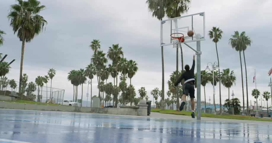A man runs and throws the basketball to the net