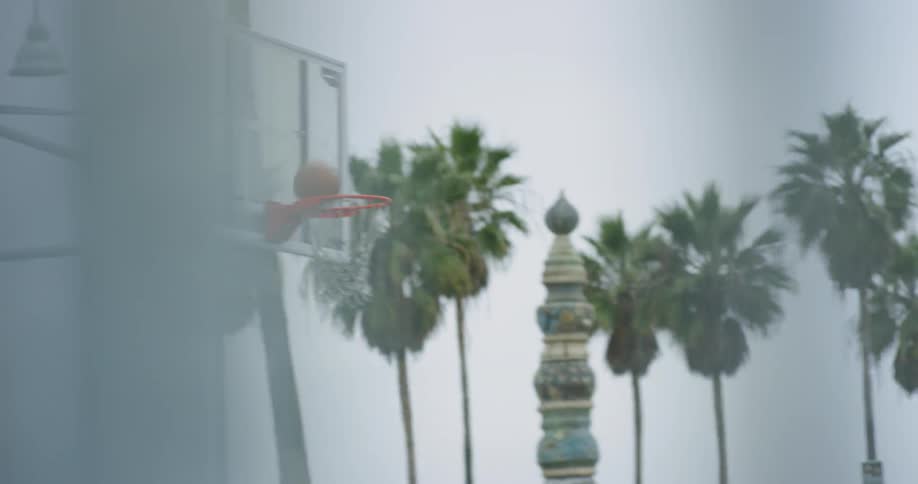 A person shoots a layup into a basketball hoop