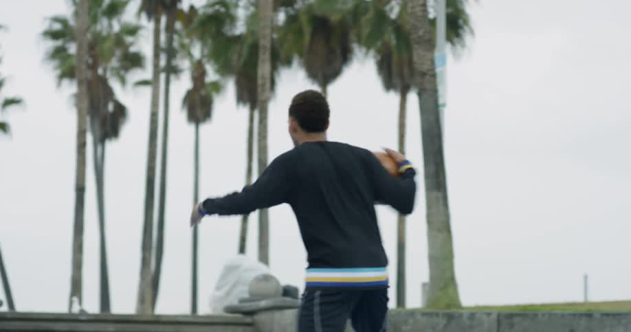 A man is dribbling a basketball around the court