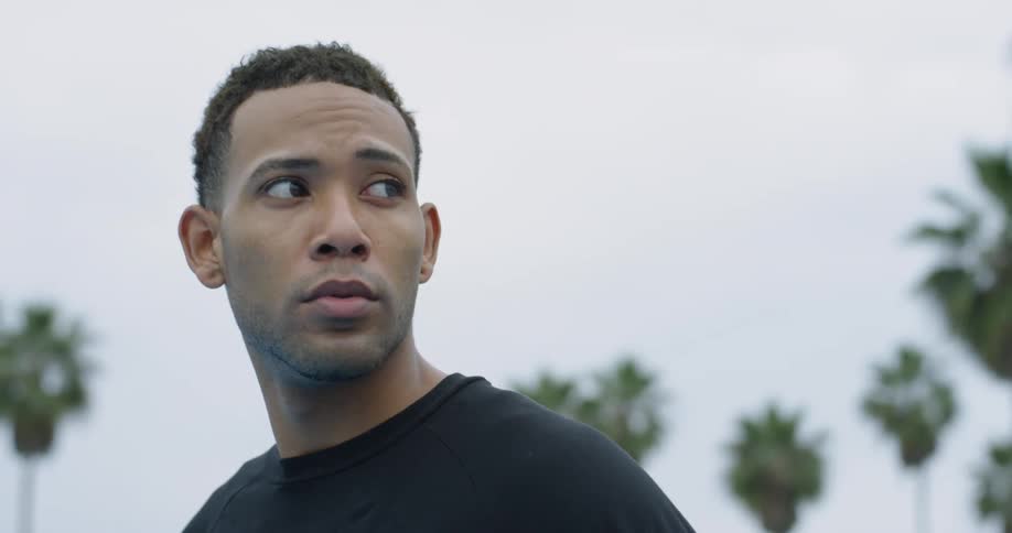 A man bounces a basketball and looks around