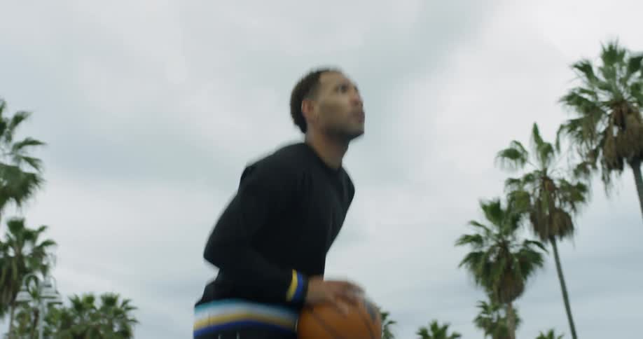 Man dribbles basketball then takes shot