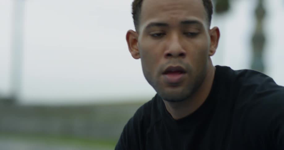 A black man bounces a basketball outside