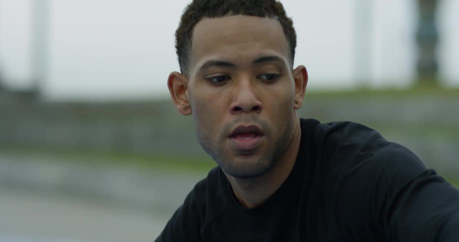 Man concentrates as he bounces a basketball outdoors