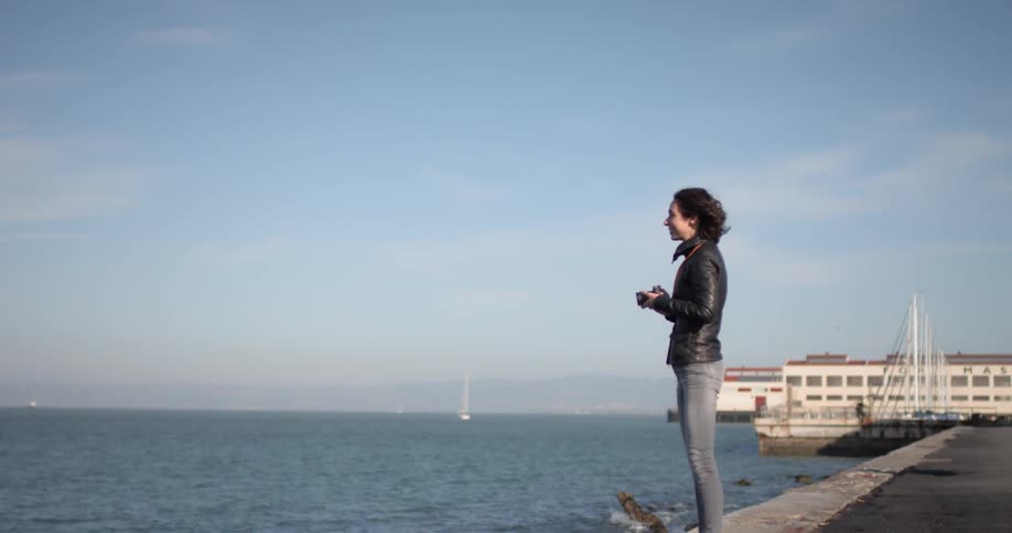 A woman is taking photographs near the shore