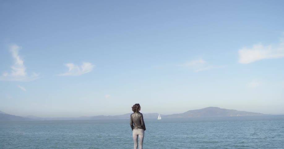 A woman is looking out over the water