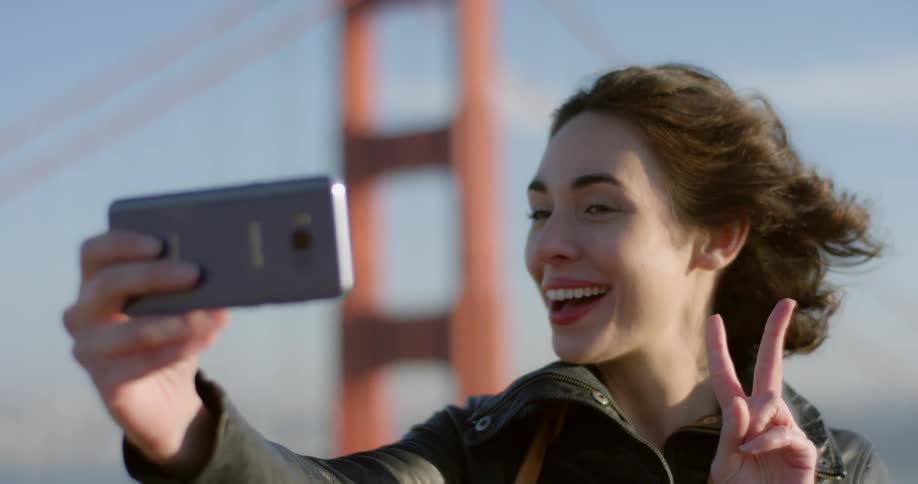 A woman takes a selfie by the golden gate bridge