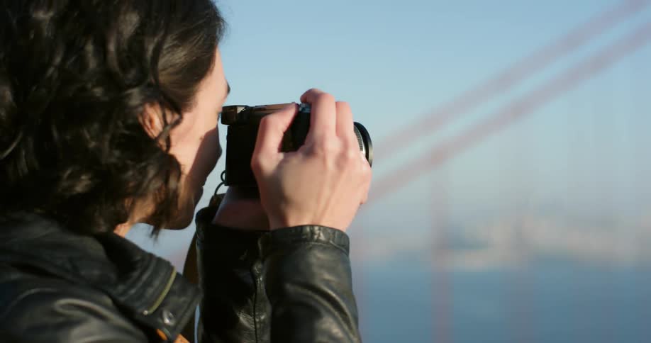 Woman takes photograph of suspension bridge