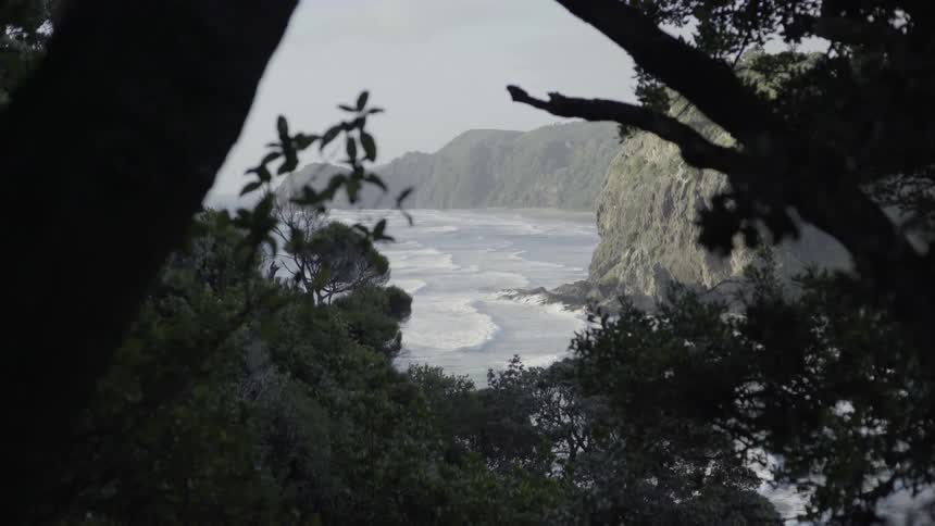 Ocean Waves Crashing Against Sandy Beach Shoreline Under Grey Sky Coastal Atmosphere.