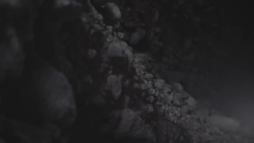 Rocks Embedded in Tar on Rough Pavement Surface Under Natural Outdoor Light.