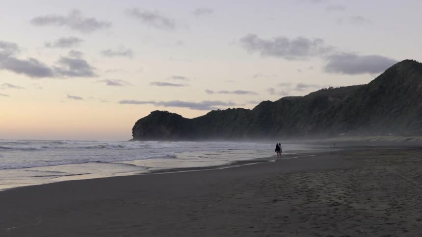 Sandy Shoreline at Sunset With Gentle Waves Under Golden Sky.