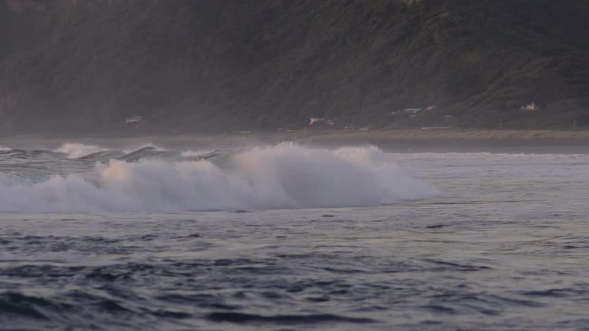 Ocean Waves Surging Toward the Beach Shoreline Under Bright Daylight in Coastal Scene.