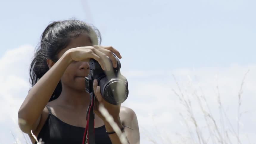 A woman is taking photographs on a cloudy day