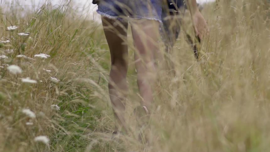 People Trekking Through a Wild Meadow With Tall Grass, Feeling Peaceful Adventure.