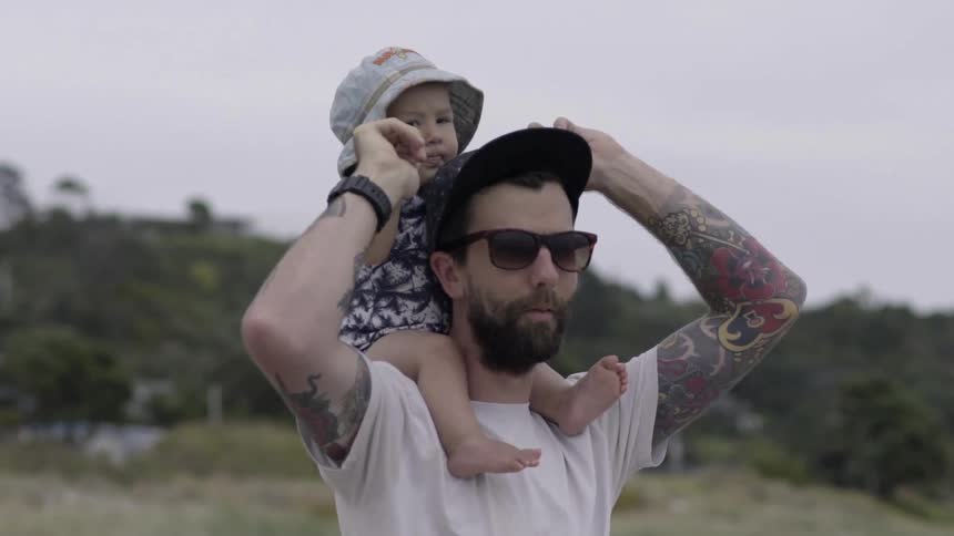 A man walking with his baby on his shoulders