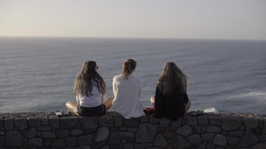 Friends Relaxing on a Tranquil Shore, Watching the Ocean and Connecting Deeply.