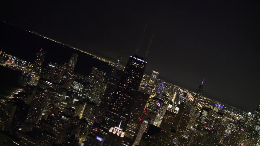 Lights on skyscrapers and city streets shine at night