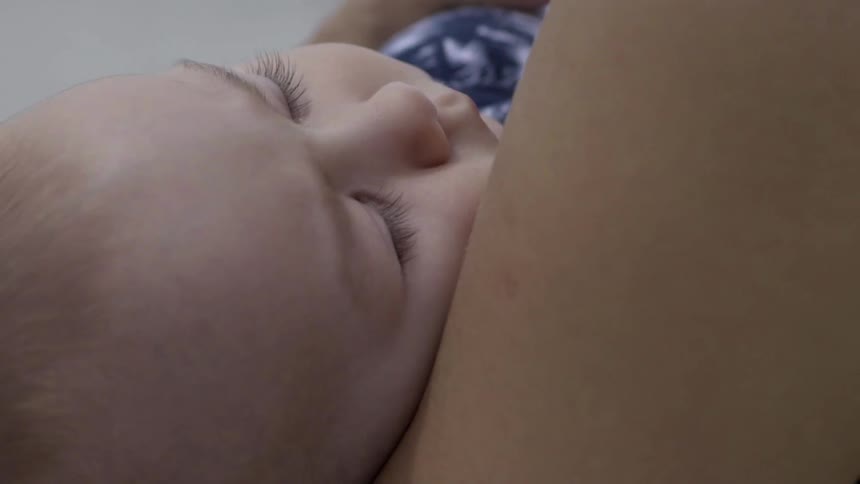Mother Holding a Sleeping Infant in Arms, Creating Calm Warmth.