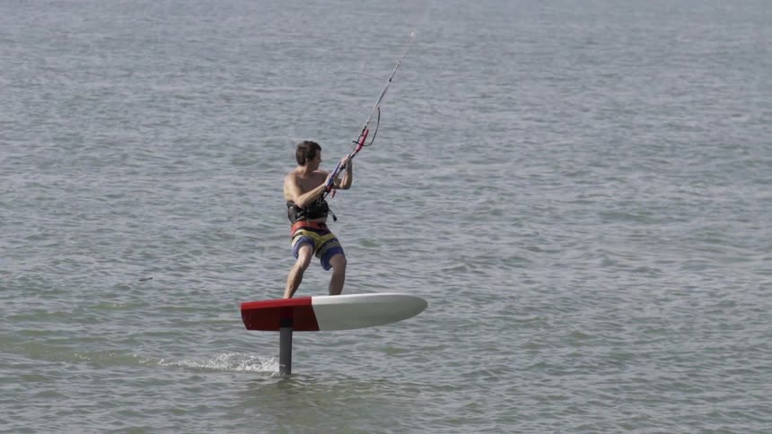 A man kite surfing while his board is almost entirely out of the water