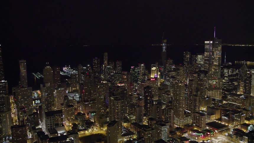 Tall buildings and brightly lit streets in a metropolis at night