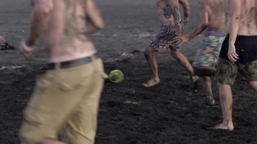 Men Playing Soccer on Rough Dirt Field, Showing Raw Energy and Team Spirit.