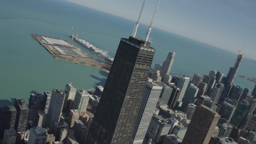 A tall brown skyscraper with other skyscrapers next to the ocean
