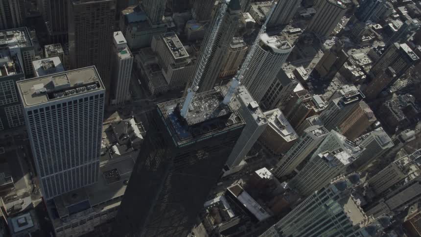 A tall darkly colored building near a bay in a large city