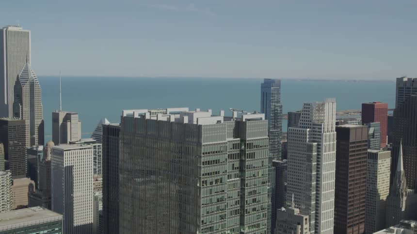A city skyline with buildings and skyscrapers and the ocean in the background