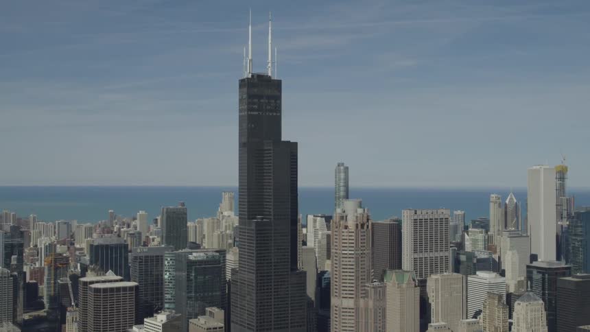 An aerial view of a city scape with a sea background
