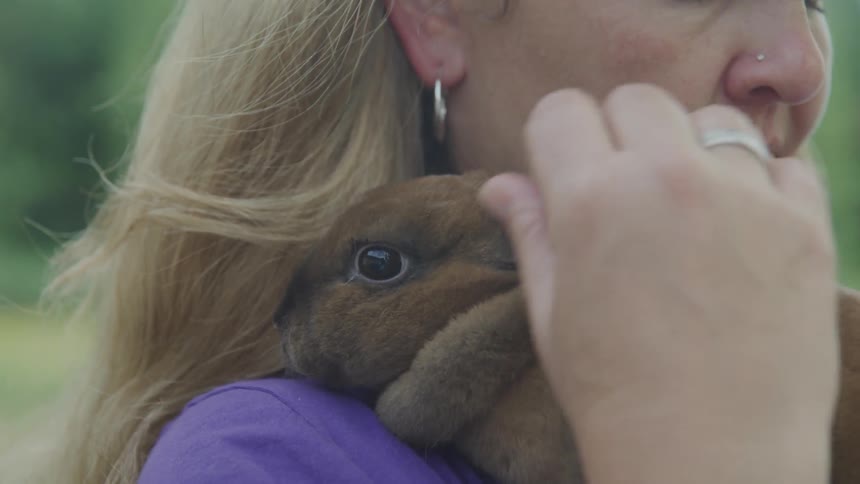 Woman cuddles and strokes bunny